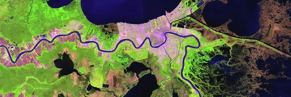 Aerial view of a river in green, captured in a satellite image, illustrating its course through the terrain.
